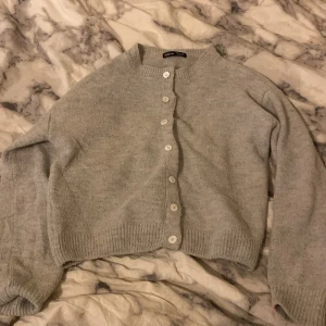 Ljusgrå kofta från SHEIN - Mysig ljusgrå kofta från SHEIN med rund halsringning och knappar framtill. Tröjan är stickad och har långa ärmar samt ribbade muddar vid ärmslut och nederkant. Perfekt för lager-på-lager och chill dagar.