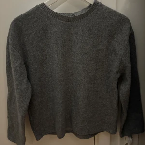 Grå stickad tröja - En enkel och stilren grå stickad tröja med rund halsringning och långa ärmar. Perfekt för lager-på-lager och passar till allt. Den är använd ett fåtal gånger och i gott skick. 