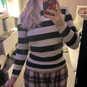 Randig tröja från Filippa K - Säljer en jätte skön tajt långärmad tröja i storlek M men passar mer i S. Tröjan har breda svarta och vita ränder, rund halsringning och en figurnära passform. Perfekt för dig som gillar klassisk stil med en modern twist, också om du gillar Y2K ✨🪩