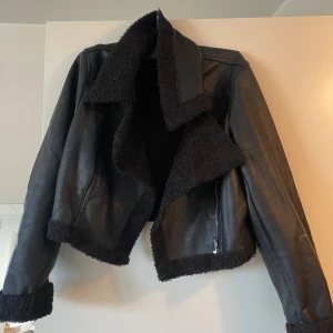 Svart teddyjacka i skinnimitation - Snygg svart teddyjacka med skinnimitation och mjukt teddyfoder. 