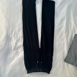 Svarta mjukisbyxor Juicy Couture XXS - Svarta mjukisbyxor från Juicy Couture i supermjuk sammet. Byxorna har dragsko i midjan, fint benslut och snygga fickor med tryckknappar bak. Perfekta för en chill och trendig look.i storlek xxs säljer för dem passar ej mig längre