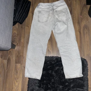 Ljusgrå raka jeans med 4 fickor använda cirka en vecka och inga skador på dom köpta för 500 kvitto finns - Snygga ljusgrå jeans med klassisk femficksdesign och raka ben. Jeansen har knapp och dragkedja framtill samt bälteshällor. Passar dig som gillar en enkel och clean look med lite loose fit. Perfekt till sneakers eller boots.