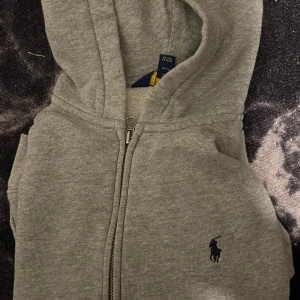 Ralph Lauren hoodie - En riktigt fet grå hoodie från polo Ralph Lauren. Pris kan diskuteras och hör av er vid frågor. Storlek 10-12!