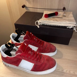 Valentino Flycrews röda - Säljer mina mycket eftertraktade röda Valentino Flycrews! Du får skorna, boxen, båda dustbagsen, extra snören + 10 extra reserv nitar!!🙌 (Allt är og) Storlek 41 men passar även 42/43. Skicket är 8,5/10!✅ Det ända är att innersulorna och hälarna är lite slitna och nötta sen har jag limmat fast vänstra sulan som hade lossnat lite men annars är skorna i toppen skick!!🤝Jag har själv satt på 5 nitar, resten är og. Skriv gärna om du har frågor eller om fler bilder önskas, pris kan diskuteras!⭐️