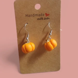 Handgjorda örhängen med pumpor - Supersöta handgjorda örhängen med små orange pumpor i miniatyr. Perfekta för dig som vill sticka ut med en lekfull och höstig accessoar. Krokar i silverfärg och detaljerad design på pumporna.
