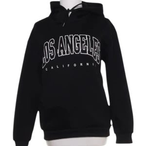 Hoodie med tryck - Svart oversized hoodie/ collegetröja i storlek S med luva, snören och ribbade muddar 💞 Tryck i vitt där de står Los Angeles California Inga defekter! Vet ej vart den är ifrån