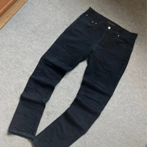 Nudie Jeans - Svarta nudie jeans i Jätte bra skick! Strlk: W31 L32, perfekt för en både en vardaglig och elegant look. 