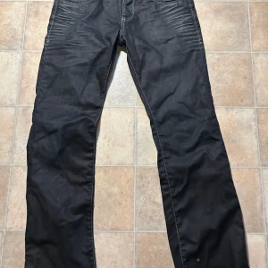 Svarta jeans från Jack & Jones - Säljer ett par retro jeans från 90 talet. Farsan använde dom 1 gång för en dejt sedan inte mer. Eftersom det är ett par dyra jeans så är priset lite högre än vanligt hoppas det inte stoppar dig från att köpa dom😁Storlek på bilden.
