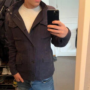 Mörkblå overshirt med fickor - Unik Vintage italiensk ”all around” jacka. Perfekt t hösten och våren.              Storlek 50/L. Modellen-185.                 Fler bilder eller frågor? Skriv.