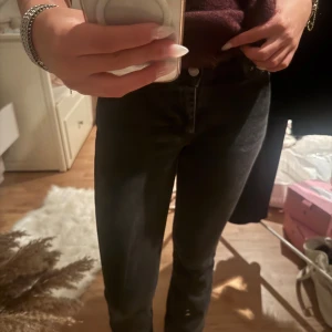 Svarta bootcut jeans  - Snygga svarta jeans med mellan midja och utsvängd ben. Jeansen har klassisk femficksdesign och stängs med knapp och dragkedja. Perfekta för dig som gillar en stilren och enkel look.