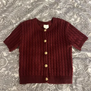 Vinröd stickad topp - Vinröd stickad topp med guldknappar från Hm. Utmärkt skick! Det finns just nu möjlighet till fri frakt!  Kolla gärna in mina andra annonser, vill du köpa flera varor så kommer vi överens om ett bra paketpris😊