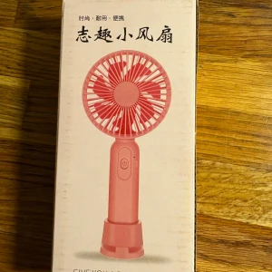 Bärbar Mini Fläkt - Praktisk och portabel mini-fläkt i rosa färg. Perfekt för resor, kontor eller hemmet. Lätt att använda med enkel knapptryckning. Produkten är ny i förpackning.