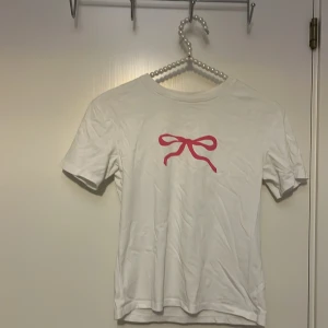 Vit t-shirt med rosa rosett🎀 - Aldrig blivit använd så bra skick💕