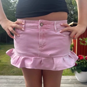 rosa volang jeanskjol - en så snygg rosa volangkjol med måtten: midjemått: 76 cm och längd i fram: 26 cm och längd i bak: 28,5 cm 🩷 har en liten fläck men inget som märks