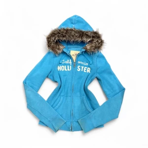 Hollister Fur Hoodie - ✨ Säljer en unik fur hoodie från märket (Hollister) ✨ Pälsen är ditsatt i efterhand för en personlig och trendig look. Storleken är (S), men den kan även passa (Xs) beroende på önskad passform. Eftersom plagget är second hand kan mindre defekter jag missat förekomma! – se gärna min bio för mer info.  💎 Priset är fast och ej förhandlingsbart.  Tvättråd: Handtvätta i ljummet vatten, var försiktig med pälsen, alternativt tvätta tröjan i en tvättpåse i tvättmaskinen 30-40grader. Undvik torktumlare. 