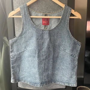 Jeanslinne från ONLY - Säljer ett snyggt jeanslinne från gamla Only märket. Linnet har en rak och loose passform, är ärmlöst och har rundad hals.