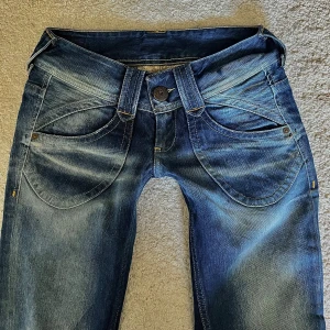 Låtmidjade Pepe Jeans - Snygga raka lågmidjade jeans från Pepe Jeans i storlek W27/L32💕Bakfickorna har dragkedja som öppning. Midjemåttet är 36 cm och innerbenslängden 80 cm 