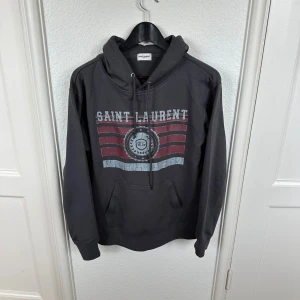Saint Laurent hoodie - Säljer nu denna sjukt feta Saint Laurent hoodie i den mest eftertraktade designen | Storleken är M men sitter som en S | modellen på bilden är runt 180 | tröjan har inga defekter eller skador och är i fint skick 