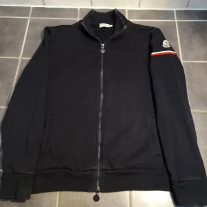 Moncler Cardigan - Navy färgad Moncler Cardigan. Nypris 4999kr Mitt pris: 1800. Strorlek L (Passar M). Köpt från Vongreven för ca 1.5 år sedan. 