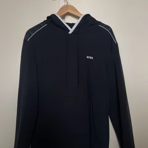 Marinblå hoodie från BOSS med huva - Väldigt bra skick, storlek L, sitter bekvämt, Hoodie med luva 