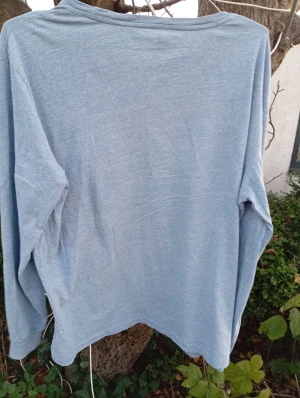 Ljusblå långärmad tröja Polo Ralph Lauren - Ljusblå långärmad tröja från Polo Ralph Lauren i mjuk bomull. Klassisk rund hals och diskret mörkblå logga broderad på bröstet. Enkel och stilren design som funkar till jeans eller chinos. Perfekt för dig som gillar clean och avslappnad stil.