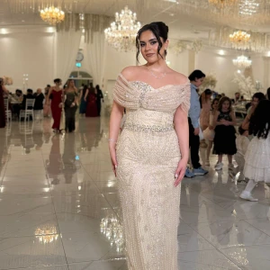 Champagnefärgad långklänning med pärlor - Säljer en elegant champagnefärgad långklänning med offshoulder och v-ringad design. Klänningen är dekorerad med pärlor och glittriga detaljer över hela tyget, samt har ett markerat midjeband med extra pärlor. Perfekt för bal eller fest, ger en lyxig och glamorös känsla. Den köptes för 2800kr från Tyskland men jag säljer den nu för 2300kr. Den är använd bara en gång. Priset går att diskutera. Storleken är 40 men passar perfekt för 38 också då jag har storlek 38. Skriv för fler bilder❤️