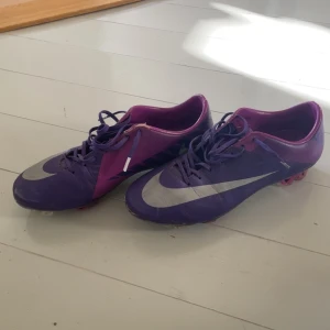 Lila och rosa Nike fotbollsskor - Säljer ett par snygga Nike fotbollsskor! Helt okej skick man ser att dom är gamla och rätt använda men går att använda! Storlek 42 pris går att diskuteras 