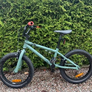 Biltema X Tailwhip BMX - Biltema X Tailwhip BMX i ljusgrön färg, 20-tums hjul, aluminiumram (6061), och robusta däck. Utrustad med reflexer och handbroms. Cykeln är i gott skick med mindre repor och slitage på ramen och pedalerna. Perfekt för barn eller ungdomar som vill ha en pålitlig BMX.