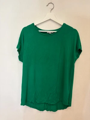 Grön t-shirt från New Yorker - Enkel och snygg grön t-shirt från New Yorker med rund halsringning och korta ärmar. Modellen är rak och lite loose fit, perfekt för en chill och avslappnad stil. Tillverkad i mjuk bomull som känns skön mot huden.