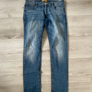 Blå jeans från Jack & Jones, storlek 32 - Snygga blå jeans från Jack & Jones med klassisk femficksdesign och ljusa slitningar framtill. Modellen har rak passform och normal midja, tillverkade i slitstarkt denimtyg. Perfekta för dig som gillar en enkel och stilren look. Passar dom som är lite över 180. Skriv för fler frågor med mera