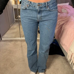Raka blå jeans från Bikbok  - Heej!🌸Säljer mina jeans i ljusblå tvätt med rak passform och hög midja. Jeansen har fem fickor och knappgylf. Perfekt för en chill och tidlös look. Jeansen är märkta med 29w och L30, passar dig som vanligtvis använd S/M. Väldigt fina jeans som köptes för ca 400 kr. Hör gärna av dig vid intresse.