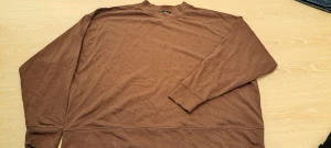 Brun sweatshirt från Lindex XL - Säljer en enkel brun sweatshirt från Lindex i storlek XL. Tröjan har rund hals, långa ärmar och är tillverkad i mjuk bomull. Perfekt för chill dagar och har en clean look utan mönster eller detaljer. Passar dig som gillar basic och oversized stil.