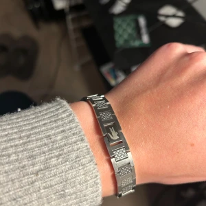 Silverfärgat armband från Lacoste - Snyggt armband från Lacoste i silverfärgad metall med rektangulära länkar och graverad krokodil på låset. Kommer med originalförpackning, ask och påse. Säljer pågrund av att det var för stort. Skick 10/10. Nypris cirka 1000 kr