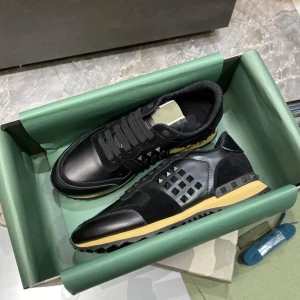 Valentino Rockrunner svarta sneakers - Svarta Valentino Rockrunner sneakers i skinn och mocka med ikoniska nitar på sidorna. Snygg kontrast med beige sula och svarta detaljer. Klassisk snörning och cool design som sticker ut. Perfekta för dig som gillar lyxiga och trendiga sneakers.