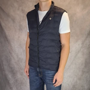 Marinblå Morris Väst - Stl S - | Snygg väst ifrån Morris! | Mycket bra skick: 8/10, endast att dunet är lite huller om buller, märks inte av mycket vid användning, annars inga defekter | Stl:S, Modellen är 175cm lång, rekommenderar att vara mellan 166-178cm lång för att sitta bra |