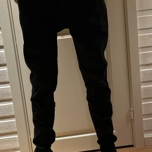 Replay anbass jeans - Säljer ett par svarta jeansbyxor med tapered passform och normal midja. Byxorna har klassisk femficksdesign och är tillverkade i mjukt jeanstyg som sitter snyggt längs benen. Perfekta för dig som gillar stilrena och enkla svarta jeans. Storlek 31/32