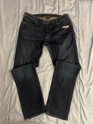 Emporio Armani mörkblå jeans i storlek: W38 L32 - Tjena, jag säljer ett par snygga Armani byxor med en rak/slim passform. Det står att de är W38 men jag har W32/33 och de passar mig bra om jag har bälte. De är i väldigt bra skick och jeansen är i ett väldigt bra material. Mått: Midja-45 cm Lårvidd-29 cm Innerbenslängd-77 cm Fotvidd-20,5 cm