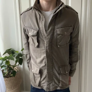 Woolrich field jacket - Woolrich field jacket brun, i storlek L. Det är ganska många små revor omkring jackan som jag ej vet är design eller ej. Men den är iaf i väldigt använt skick men har liksom inga större defekter som förstår själva användningen av jackan ❣️, väldigt snygg och eftertraktad jacka. Modellen är 180 cm 75 kg kom med frågor 🙏