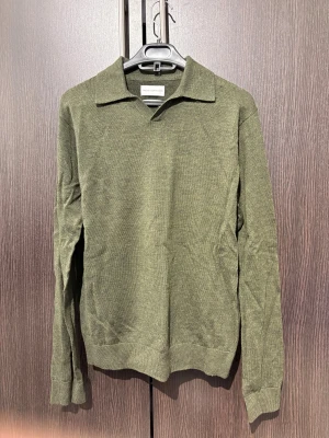 Olivgrön stickad polotröja Thease glory days - Snygg olivgrön stickad polotröja från These Glory Days i merino i storlek s. Den är helt oanvänd