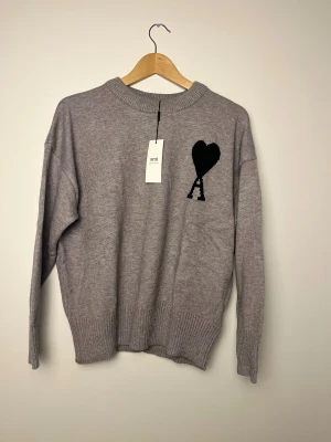 Ami Paris Tröja Stickad - Hej! Säljer denna otroligt snygga tröja från Ami Paris. Den är jätteskön att ha och är i ett bekvämt stickat material. Tröjan är i storlek M. Helt oanvänd. Hör av dig om du undrar något! Priset kan diskuteras. 