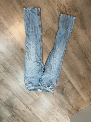 Abrand Jeans ljusblå raka jeans - Säljer ett par ljusblå jeans från Abrand Jeans i rak modell. Jeansen har klassisk femficksdesign, gul kontrastsöm och är tillverkade i ekologisk bomull.