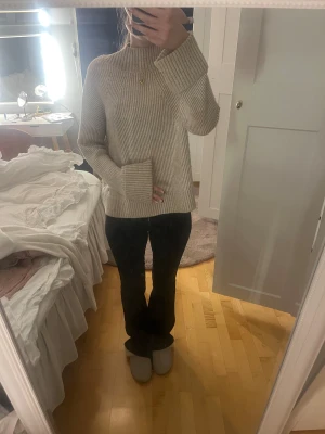 Beige ribbad stickad tröja Pernilla Wahlgren - Säljer en beige stickad tröja från Pernilla Wahlgren i storlek S. Tröjan har ribbad struktur, lång ärm och hög hals. Perfekt för dig som gillar en clean och chill look med lite extra mysfaktor. Passar dig som vill ha en enkel men snygg tröja till hösten och vintern.