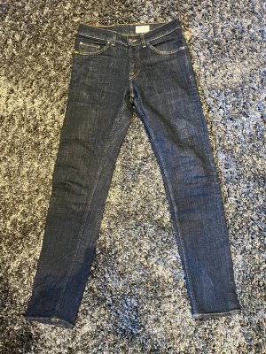 Tiger of Sweden mörkblå jeans - Snygga mörkblå jeans från Tiger of Sweden med klassisk femficksdesign och kontrastsömmar. Modellen är skinny med smal passform och raka ben. Jeansen har knapp och dragkedja framtill samt läderpatch bak. Perfekt för dig som gillar stilrena och moderna jeans.                                           Storlek är 28/30’’.                                                             Pris kan diskuteras!