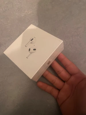 Apple AirPods (4th generation) med MagSafe-laddningsetui - Snygga och populära Apple AirPods (4th generation) med MagSafe-laddningsetui. Produkten är i originalförpackning, med tydliga bilder på både framsida och baksida. Perfekt för trådlös musik och samtal.
