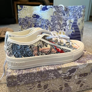 Dior Walk'n'Dior sneakers - Väldigt eftertraktade unika sneakers från Dior. broderat mönster i blått, vitt, svart, rött och orange. Skorna har vit sula med Dior-logga. Snygg kontrast mellan färgerna och detaljer som gör dem till ett statement piece. Köpta från vestaire collective.  Jätte fint skick. Kom gärna med bud och frågor! vill gärna bli av med skorna ganska snabbt pga kommande flytt därav det billiga priset. 🥰 bra skick använda 3 gånger, och självklart äkta 🫶🏼 
