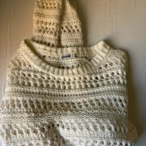 Vit stickad croppad tröja från Ghanda - Säljer en vit stickad tröja från Gharanda i storlek S. Tröjan är croppad med lång ärm och har ett snyggt hålmönster som ger en chill vibe. Perfekt att slänga på över ett linne eller bikini. Rund hals och mjukt material. 100% bomull