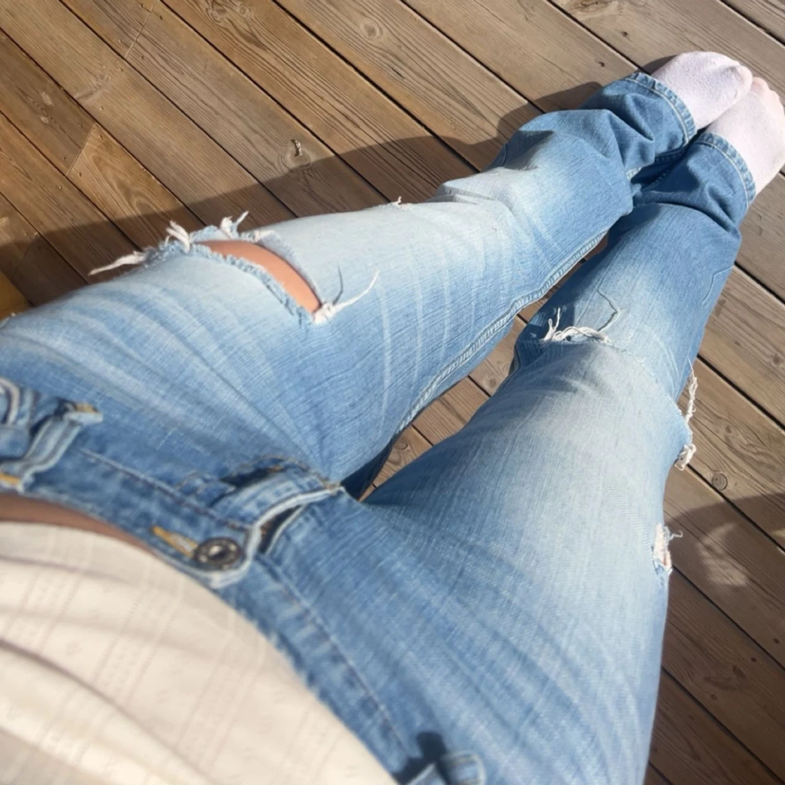 Ljusblå bootcut jeans med slitningar