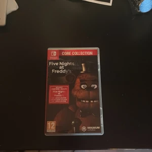 Five Nights at Freddy's Core Collection (Nintendo Switch) - Five Nights at Freddy's Core Collection till Nintendo Switch. Komplett med fodral och spelkort, i mycket gott skick. Innehåller flera spel i serien. Som till exempel 1an, 2an, 3an, 4an och Auster location så den kommer med 5 olika spel i ett. Fodral och kort ser ut att vara i fint skick utan synliga skador eller slitage.