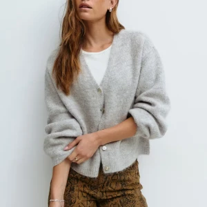 Grå stickad kofta från Gina Tricot - Aldrig använd! Mysig grå stickad kofta med v-ringning och knappar framtill. Koftan har en mjukt material som känns skönt mot huden. Perfekt till hösten och vintern!!