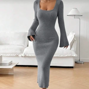 Grå ribbad långärmad klänning - Supersnygg grå ribbstickad långklänning med utsvängda ärmar och fyrkantig ringning. Klänningen är väldigt stretchig den är S men passar mer som M och L, jag är 168 och den går till mitten av smalbenen typ. Perfekt till vintern.